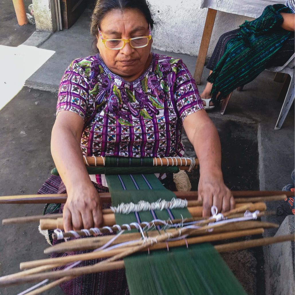 Maria tejiendo en el telar desde su hogar